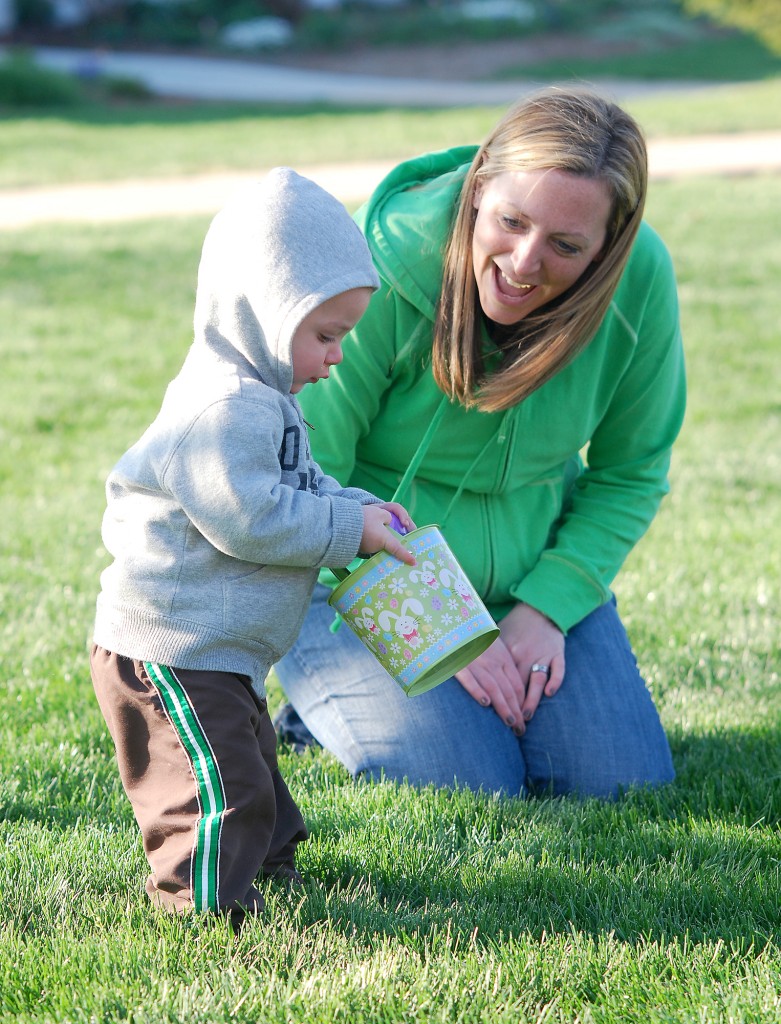 Patty Wittmann encourages Brady Wittmann, 15 months, as he collects eggs. (File photo by Robert Herrington)