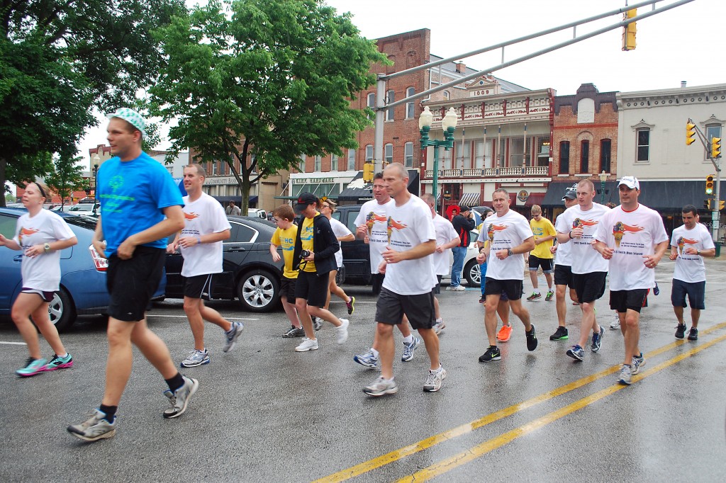 Local law enforcement officers and Special Olympics athletes circle the downtown Noblesville Square at the conclusion of the annual Torch Run. 