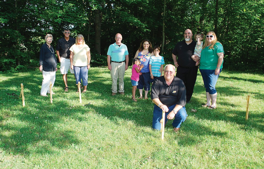 From left: Mary Sue Rowland, Bill and Sue Childs, Garry Warren, Ashley, Suzanne and Christian Brooks, Kirk Forbes and Jim, Madeline and Brandi Bates place temporary wooden stakes in the location of the Angel of Hope Memorial Garden to kick off its fundraising efforts. (Photos by Robert Herrington)
