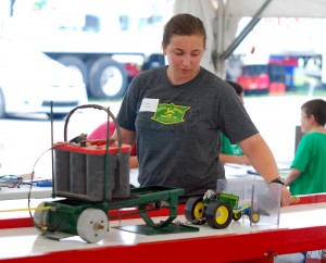 Heartland 4-H’ers’ Diana Rulon guides her 1/16th scale toy tractor during the model tractor pull on July 22. (Photo by Robert Herrington)