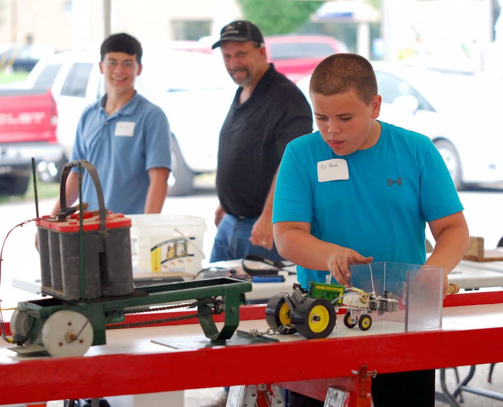 Eli Ross guides his 1/16th scale toy tractor during the model tractor pull on July 22. (Photo by Robert Herrington)