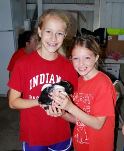 Harey Hoppers 4-H Club members Abigail Zagel, left, and Megan Dailey hold a baby rabbit. (Photo by Robert Herrington)
