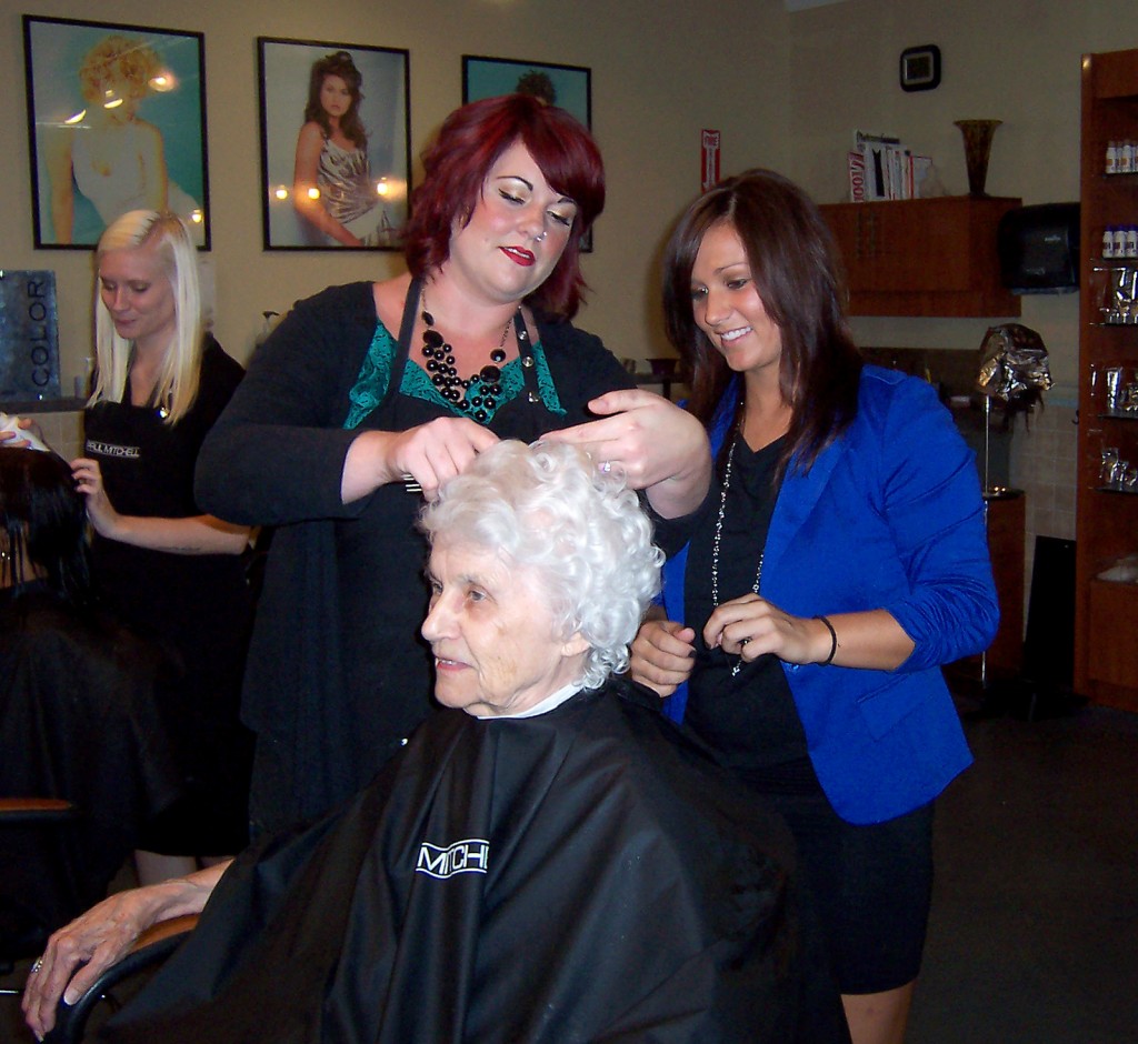 Sarai Thacker, director of advanced education, shows Westfield’s Sarah Colby a technique when cutting the hair of Noblesville resident Elizabeth Railey. (Photo by Patricia Griffin Mangan)