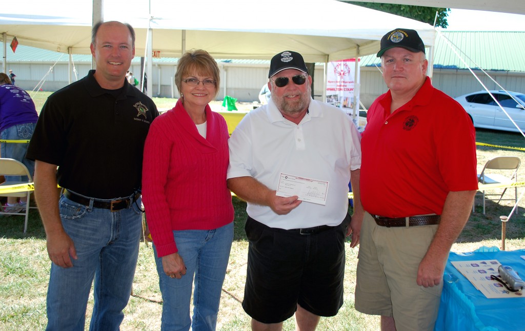 Debbie and Jim Laird, center, present a $1,000 check on behalf of the Jake Laird Memorial Fund to Sheriff Mark Bowen, left, and David McCormick for the Hamilton County Project Lifesaver program. (Photo by Robert Herrington)