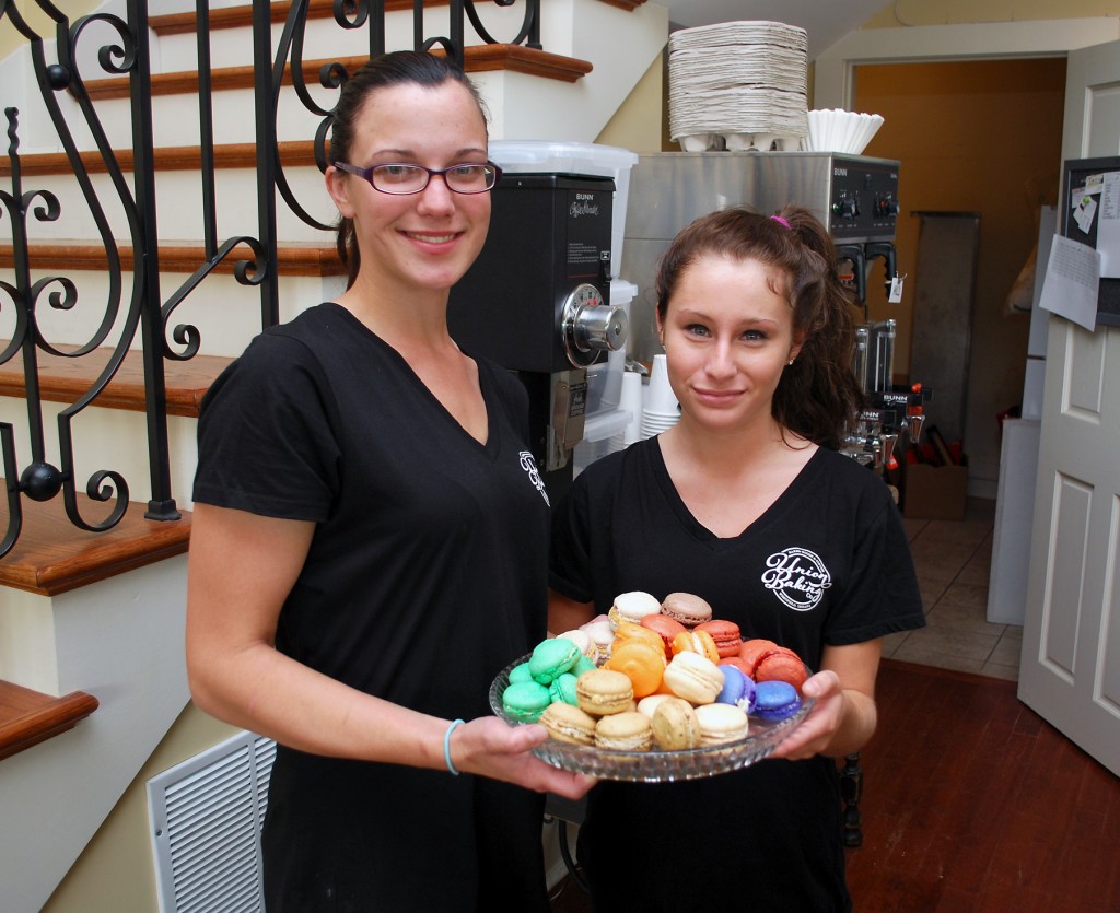 Manager Lauren Swartz, left, and Joanie Nowosielski hold a tray of the various flavors of macaroons Union Baking Co. offers at 100 N. Union St. (Photo by Robert Herrington)