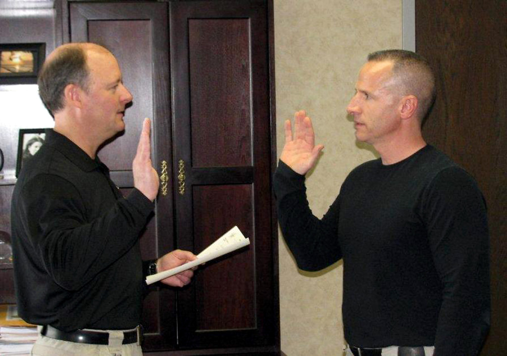 Sheriff Mark Bowen, left, administers the oath to Deputy John Cline, the newest addition to the patrol division, on Jan. 9. (Submitted photo) 