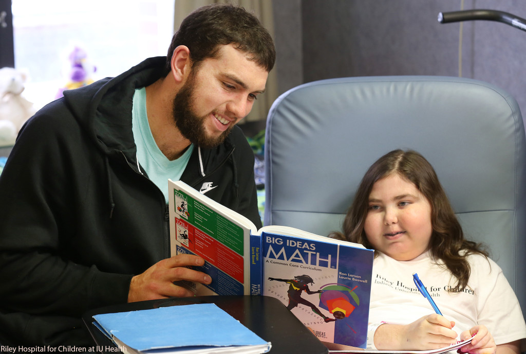 Andrew Luck, quarterback for the Indianapolis Colts, reviews schoolwork with Riley Hospital patient, Emily Hume, 12, of Seymour, Ind. 