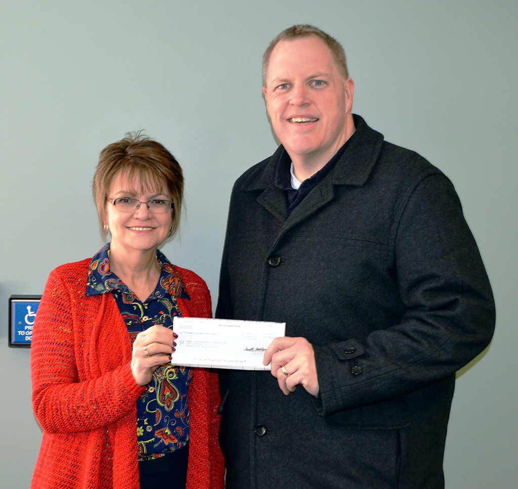 Debbie Laird, Janus vice president of development and transportation, accepts a $5,000 grant from John Mueller of the TJX Foundation. (Submitted photo)