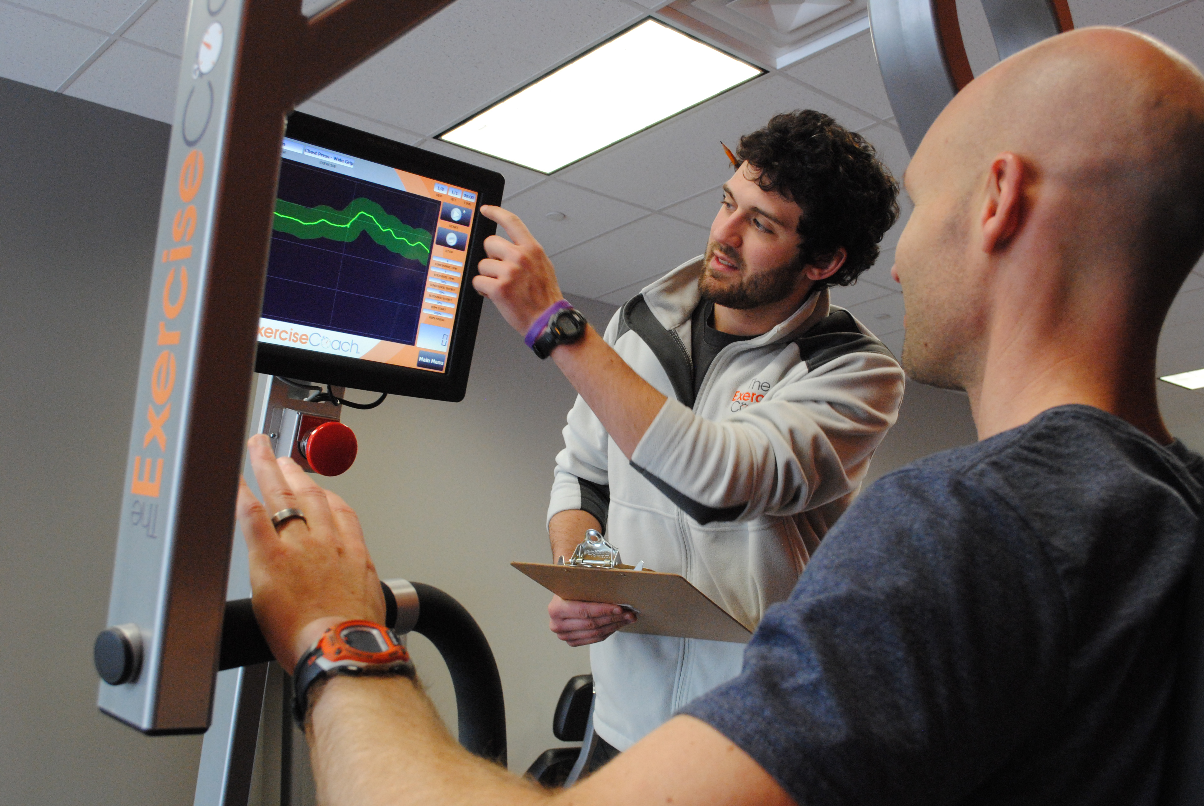  Trevor Junga, lead coach at The Exercise Coach, demonstrates a fitness graph on a bench press machine. (Staff photo) 