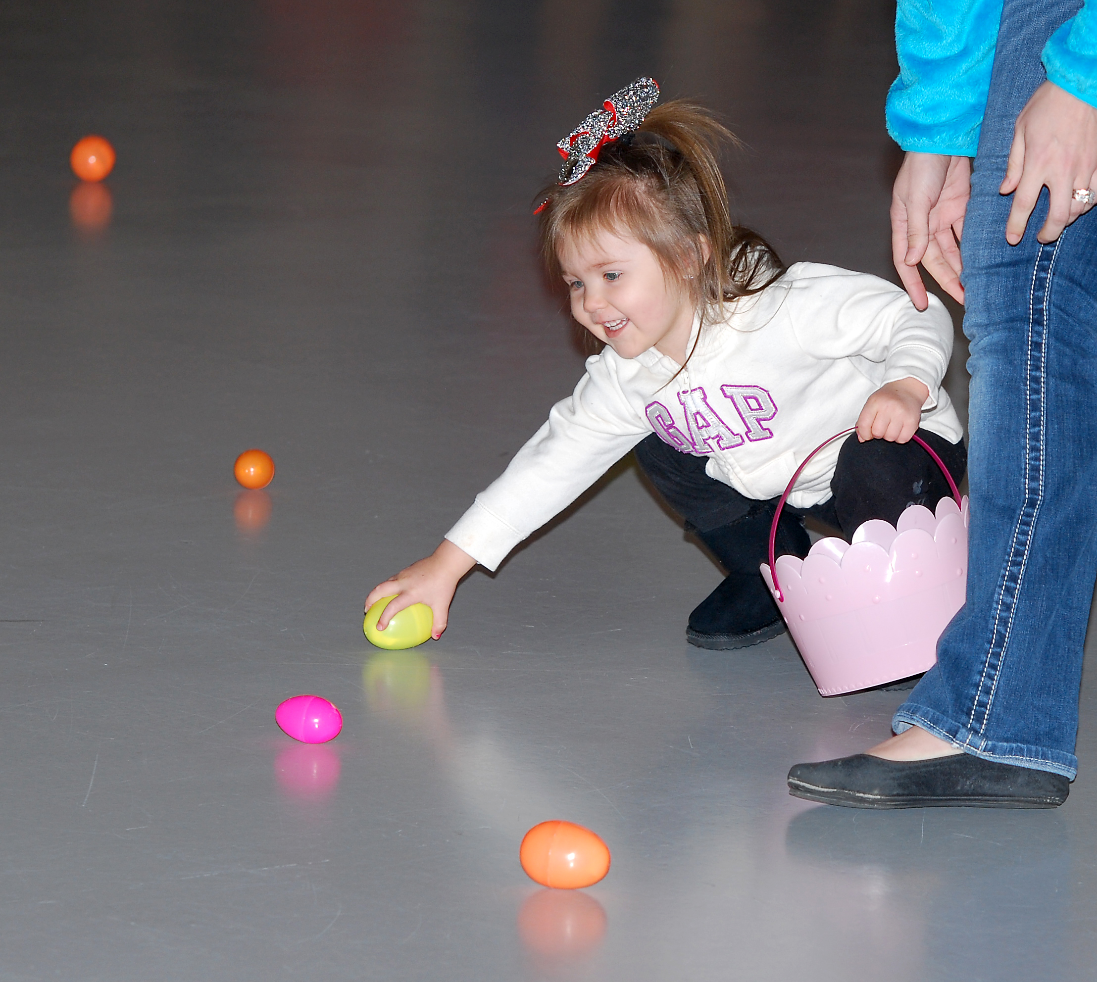 Paislee Tuell, 2, grabs an egg inside the Hamilton County 4-H Exhibition Center during last year’s community egg hunt. (File photo) 