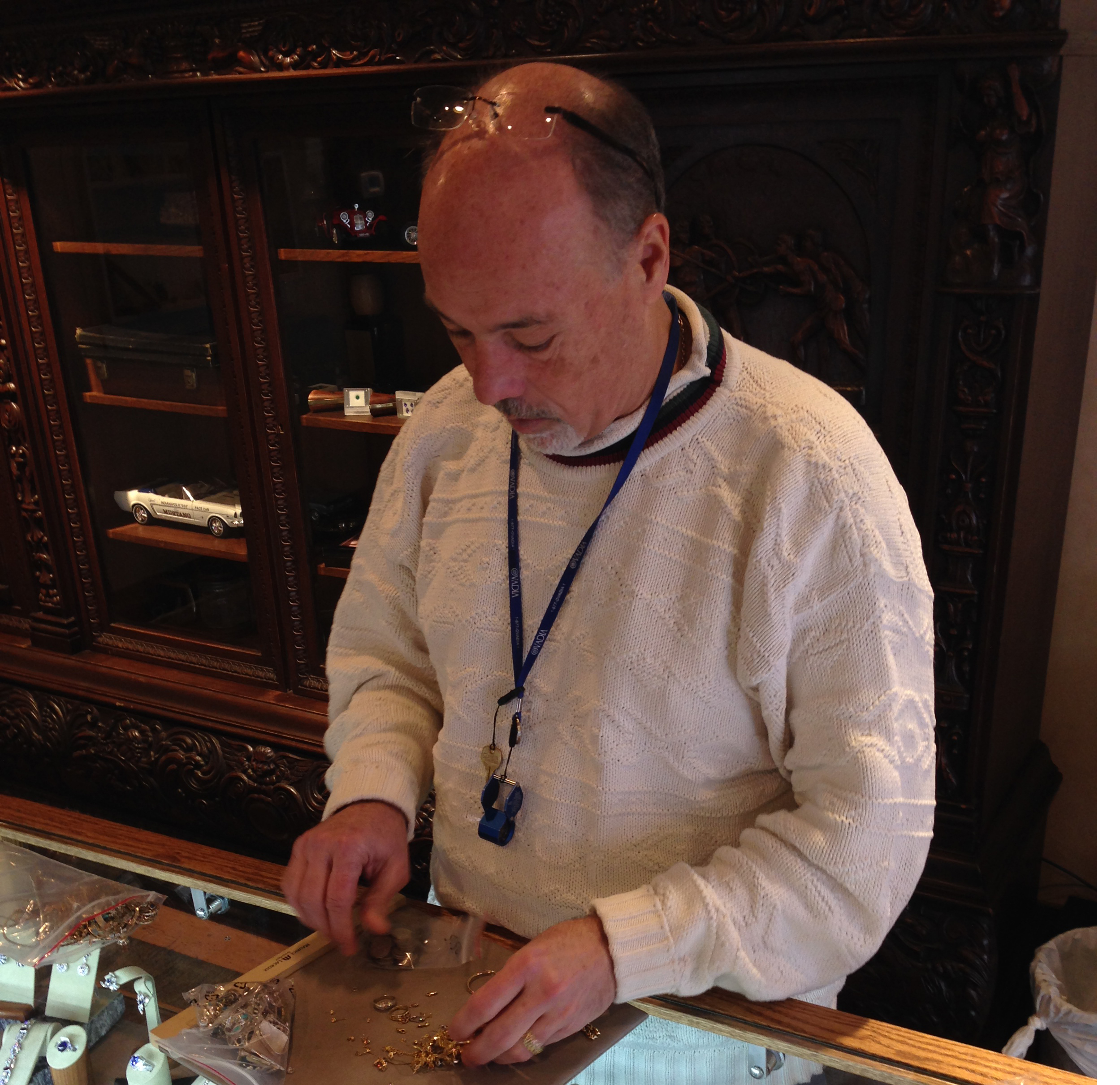 Owner of Midwest Jewelers and Estate Buyers, Brian McCall, sorts through a bag of gold and silver. McCall said his business is a ministry, because he often helps clients who are going through a difficult time. Photo by Sophie Pappas. 