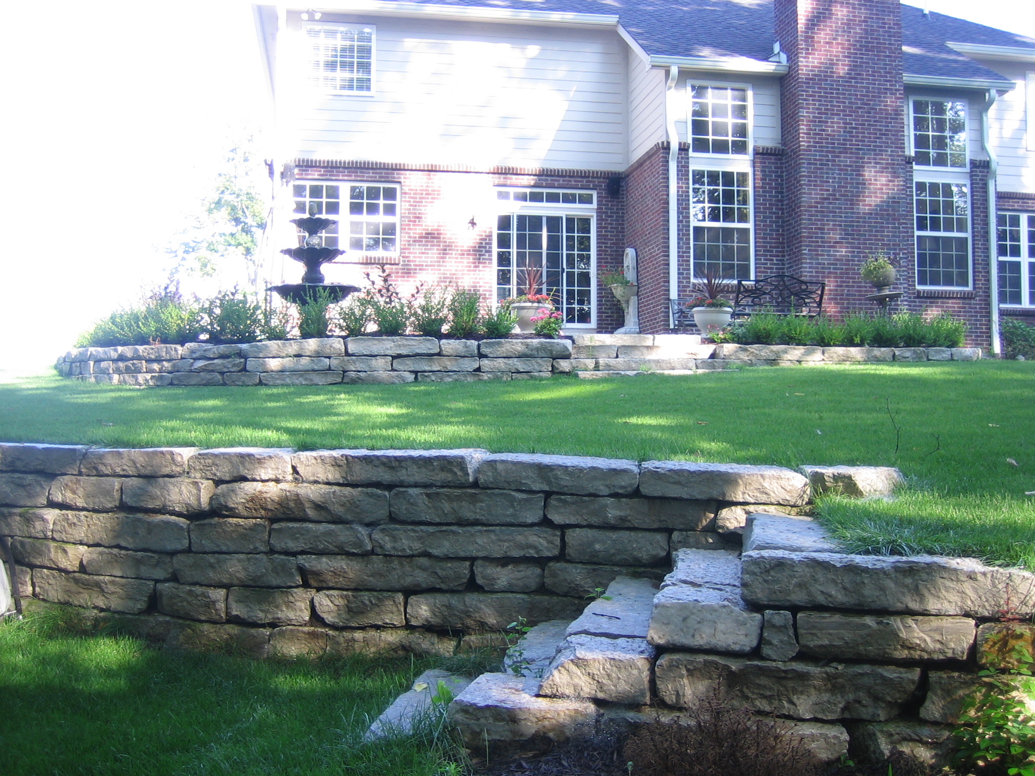 A stone wall and steps on a driveway provide the “triple threat” elements to improve landscaping. (Submitted photo) 