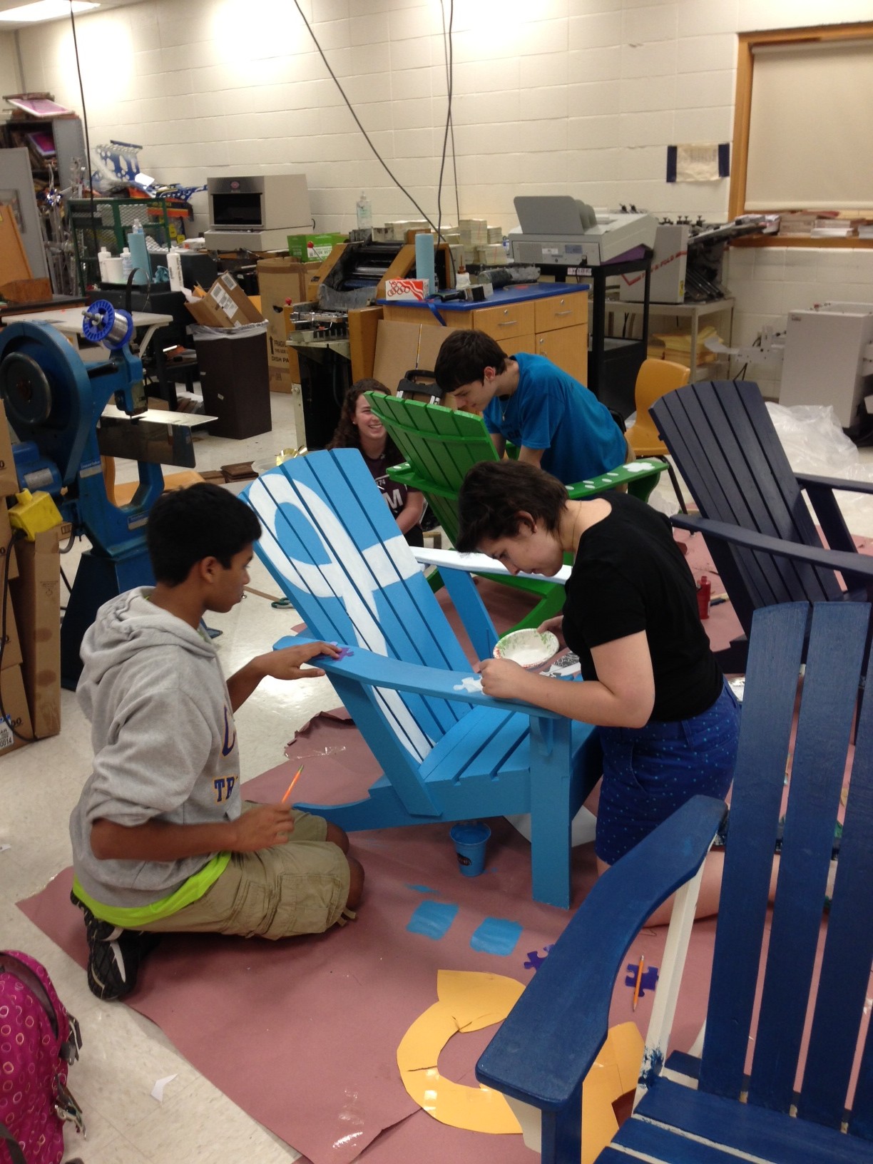 Members of the TechHOUNDS robotics club of Carmel High School work to paint the Adirondack chairs prior to the June 14 Gallery Walk. (Submitted photo)