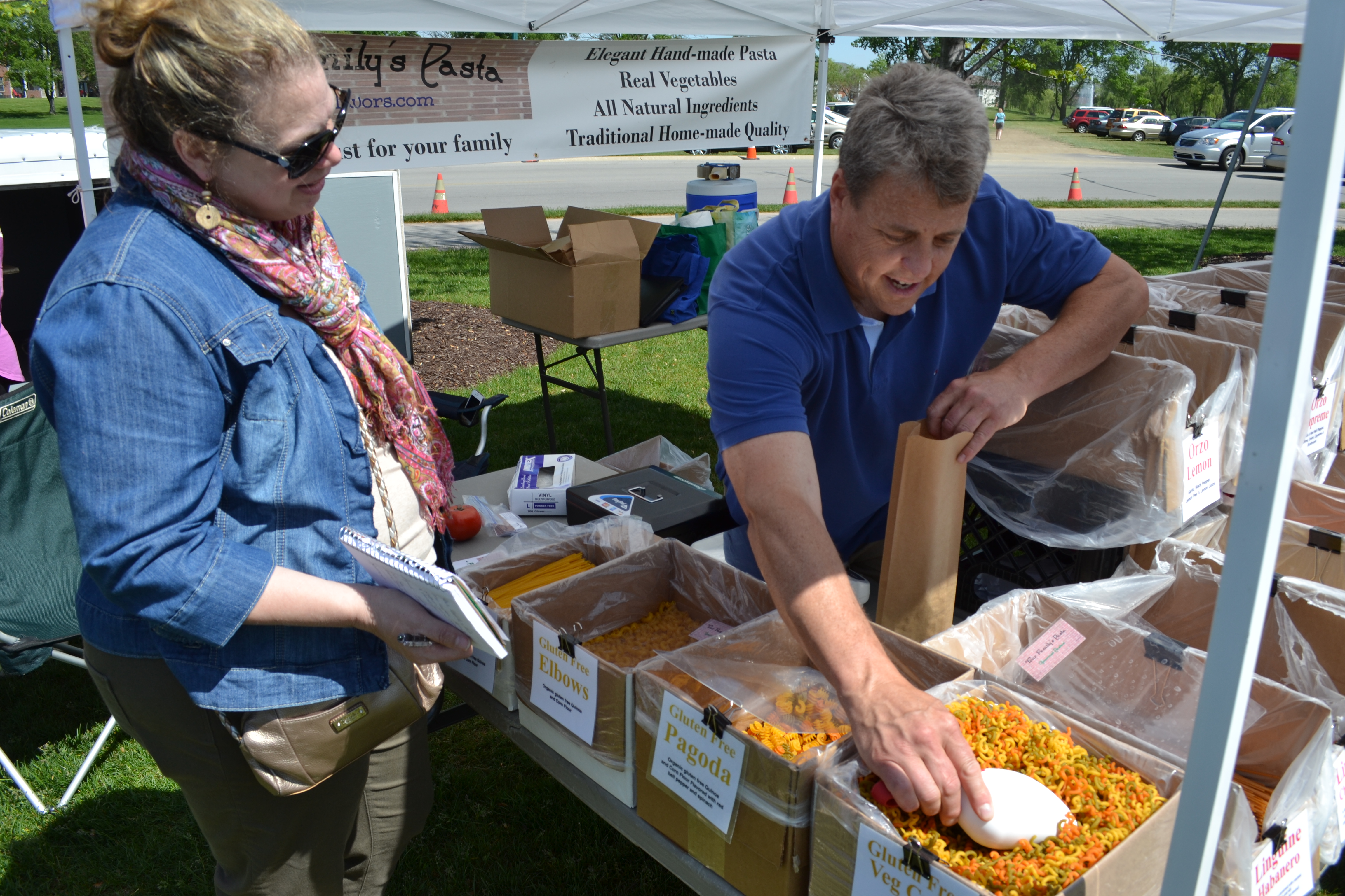 Lori Goldsby checks out fresh pasta at “Your Family’s Pasta” booth with owner Jerry Stevens at Fishers Farmers’ Market. (Photo by John Cinnamon)