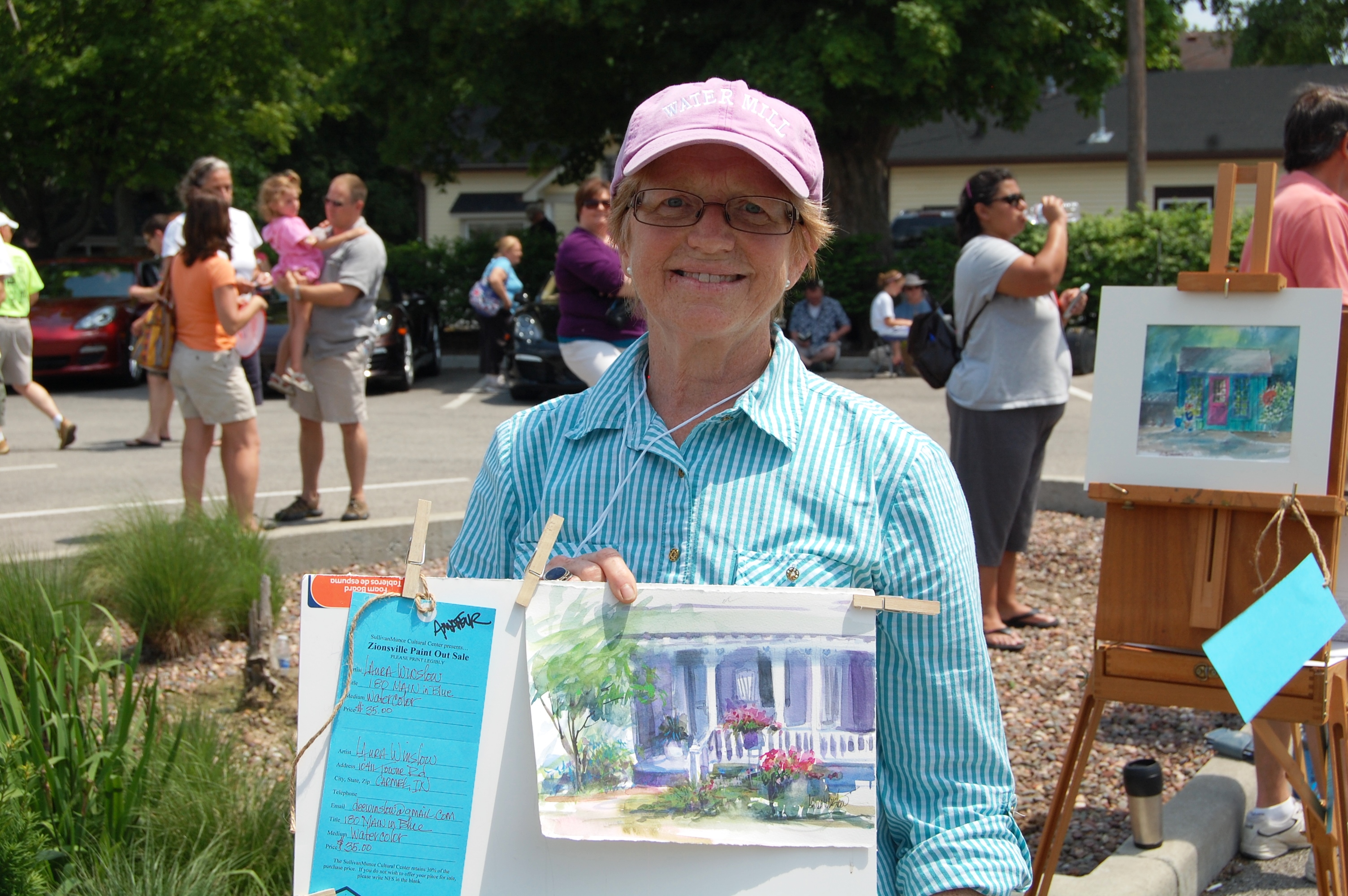 Painter Laura Winslow holds her watercolor painting during last year’s Paint Out. This year the event will be on June 14. Submitted photo.