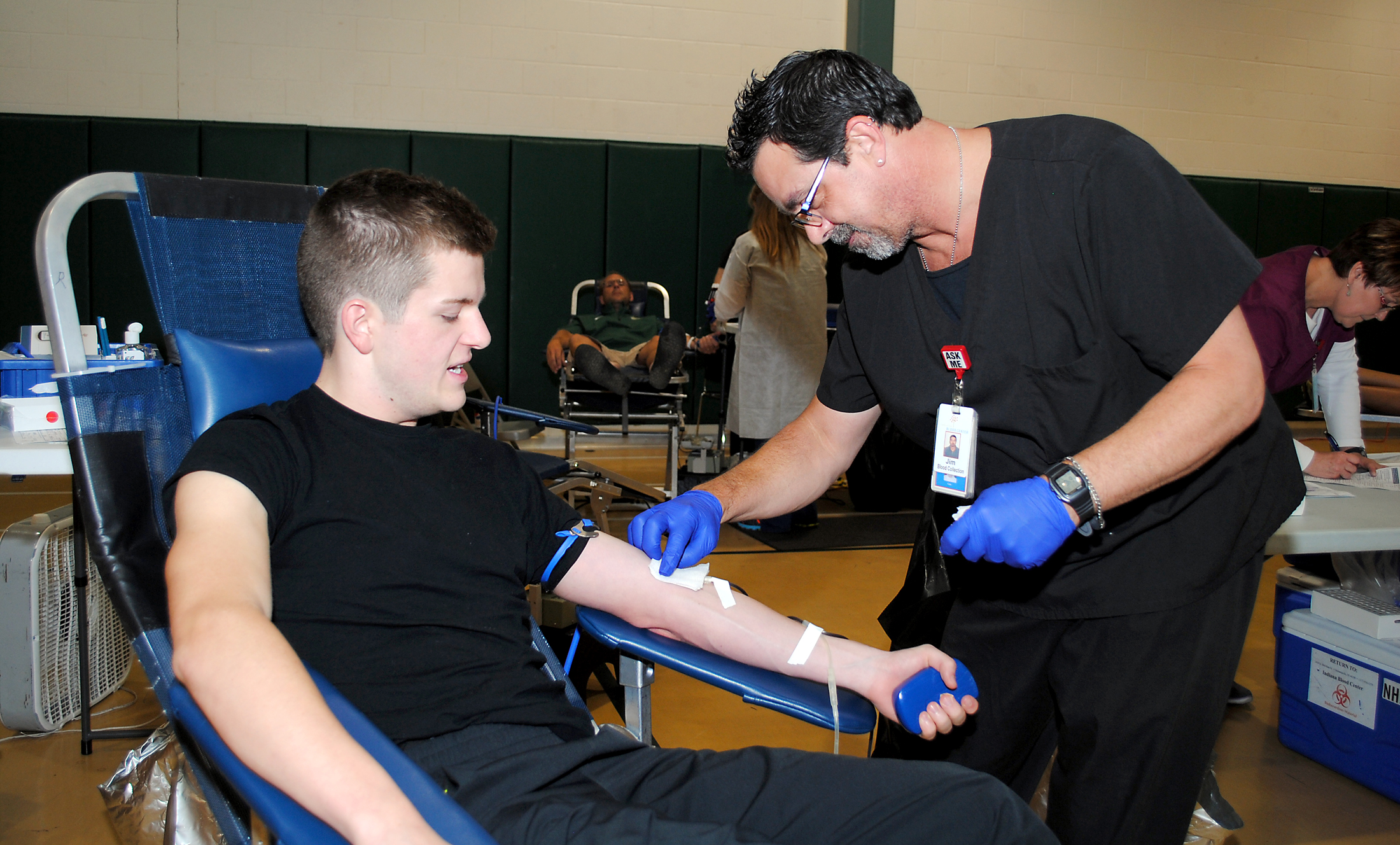 Jim Madewell of the Indiana Blood Center covers the needle in Westfield High School senior Corbin Atkins’ arm as he donates to the Colts Leadership Challenge Blood Drive on July 16. (Photo by Robert Herrington)