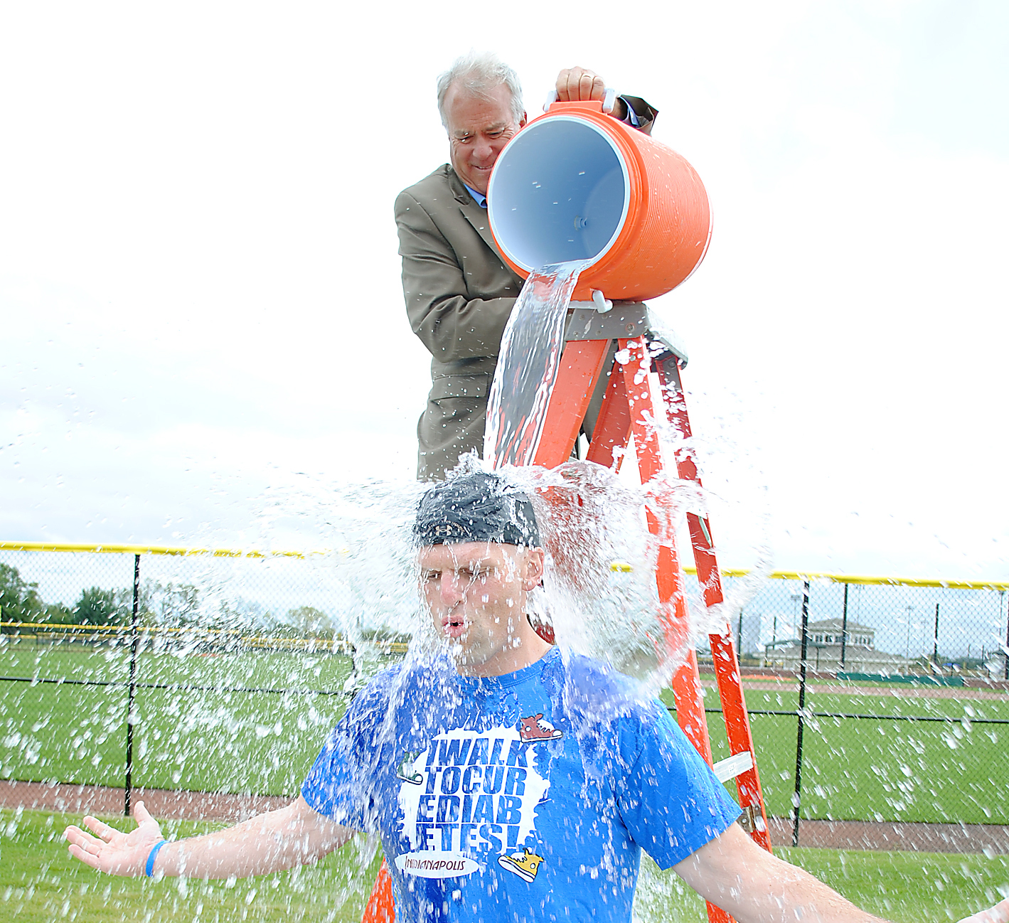 Mayor Andy Cook dumps a cooler of ice water on deputy mayor Todd Burtron at Grand Park Sports Campus on Sept. 12. (Photo by Robert Herrington)