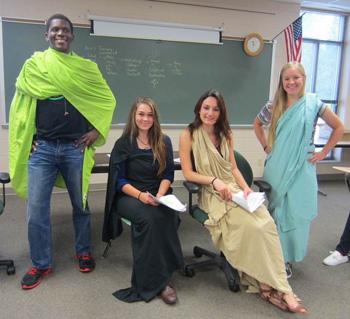 ZCHS students in the AP English Language & Composition class pose in their togas for their group projects about Ancient Greek literature and philosophy. This assignment asked the students to examine some of the key philosophies of Socrates, Plato, and Aristotle and connect them to Sophocles’, *The Theban Plays*. The dialogue that the groups created reflected how the philosophers would have reacted to the plays, based on what they had learned about each philosopher.  Pictured left to right: Bryan Wilson, Avery Wright, Alex Yiannoutsos and Claire Badger