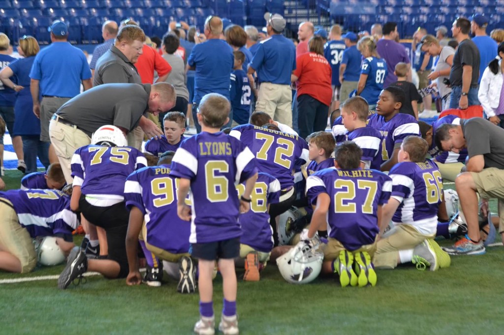 Players and coaches take time to pray before the game.