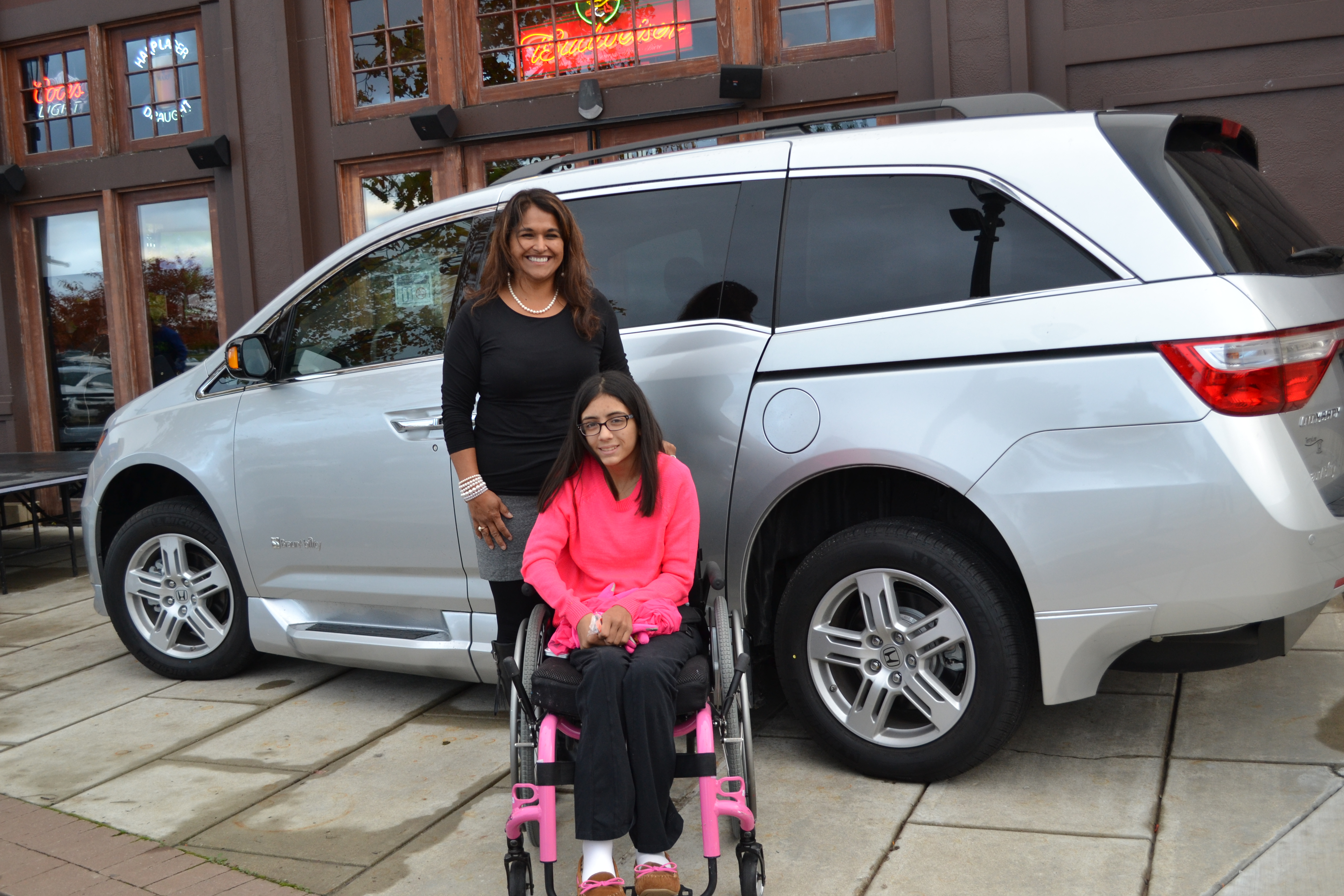 Mia Carter with her mother, Isabel, and their new van bought with contributions through Pub Theology and Samantha’s House and Van. (photo by Ann Craig-Cinnamon)