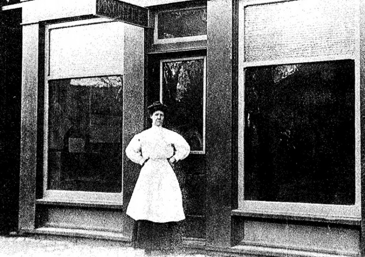 Post office windows reflect buildings across the street in this early photo of an unidentified postal employee. (Submitted photo courtesy of the Sullivan Museum)