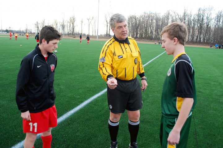 Referee Matt Curtis asks Westfield Select’s Michael Kwiatkowski to call the coin flip with Wilson Freige of FC Pride on March 14, 2014. It was the first coin flip and soccer game at Grand Park. (File photo)