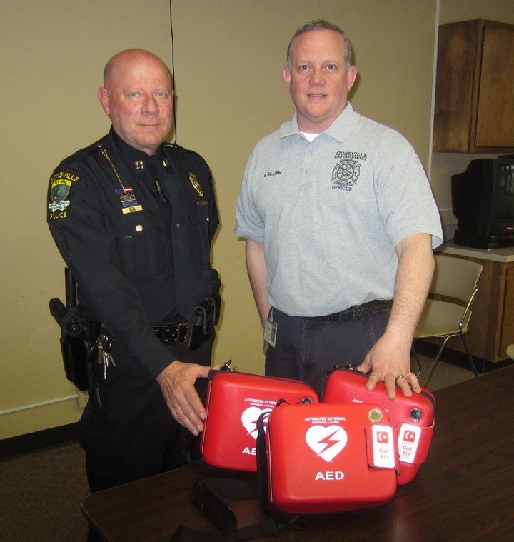 ZPD Capt. Bob Musgrave (left) and ZFD EMS Division Chief Steve Gilliam display the new AED units the departments worked together to purchase. (Submitted photo)