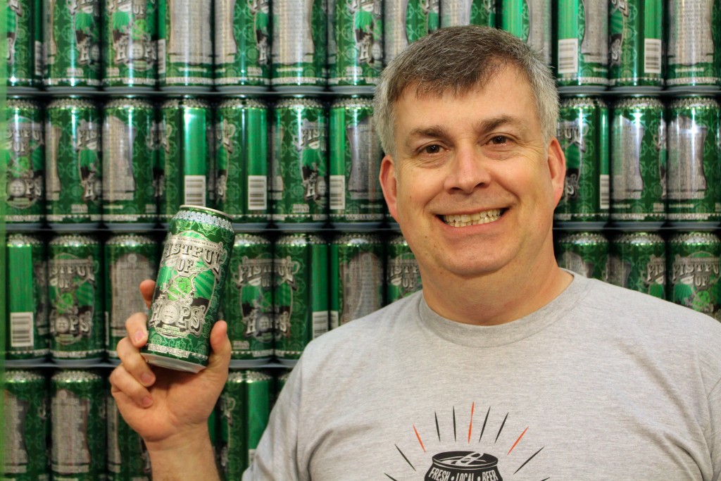 Sun King co-owner Dave Colt shows off one of the company’s craft beers, Fistful of Hops. (Photo by James Feichtner)