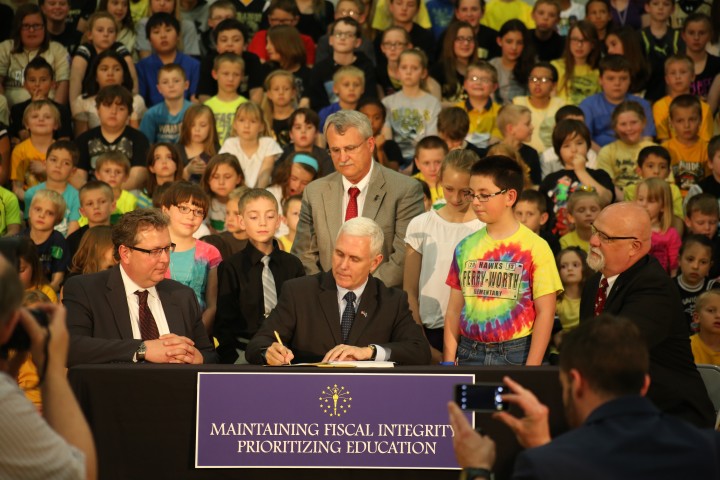 Students from Perry Worth Elementary School in Lebanon look on as Gov. Mike Pence signs HEA 1001.