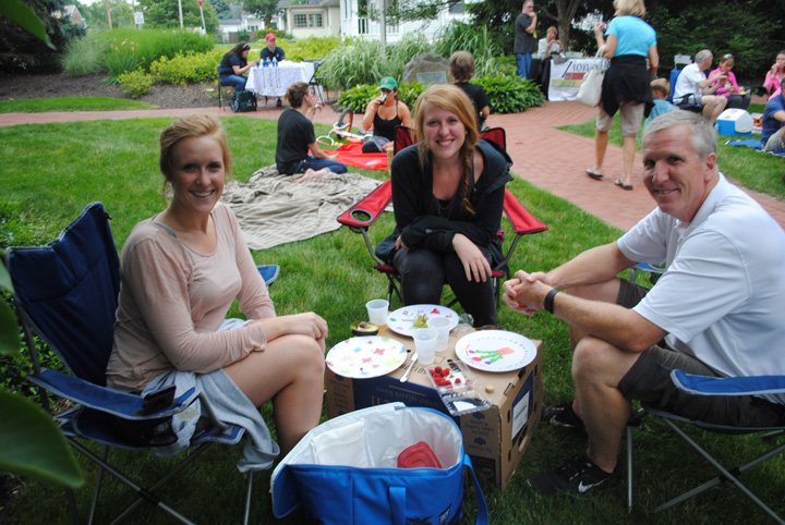 From left: Tori, Abby and Richard Nelson set up a comfortable area to sit and listen to the music. (Photo by Anna Skinner)