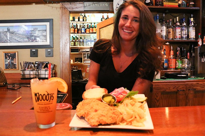Brittany McCoy holds a tenderloin sandwich from Woodys Library Restaurant. (Photo by Sam Robinson)