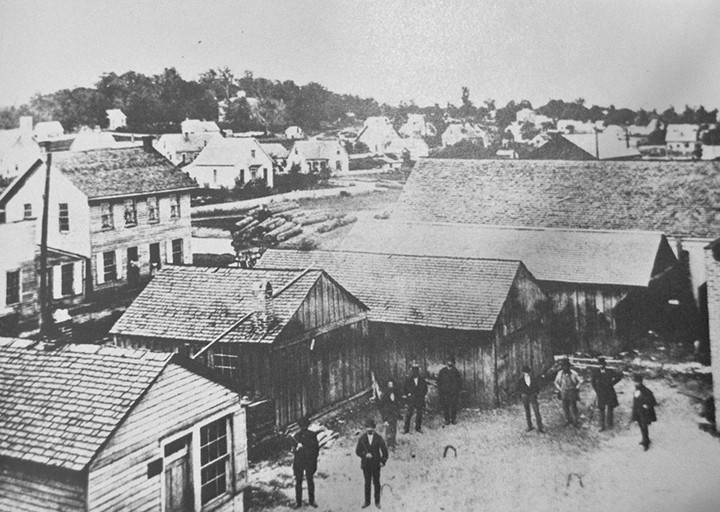 This photo shows a slice of downtown during 1885. The picture was probably taken from the second story of the wagon wheel factory, where the Friendly Tavern now resides on the northwest corner of Main and Hawthorne streets. A two-story boarding house, pictured here on the left side, served travelers debarking from the train. (Photo courtesy of SullivanMunce Cultural Center)