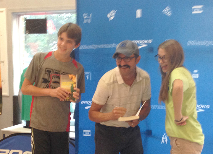 Zach Steinmetz, left, of Fishers, and Katie Darragh, right, of Lawrence attended a book signing with Bill Kenley. (Photo by Mark Ambrogi)
