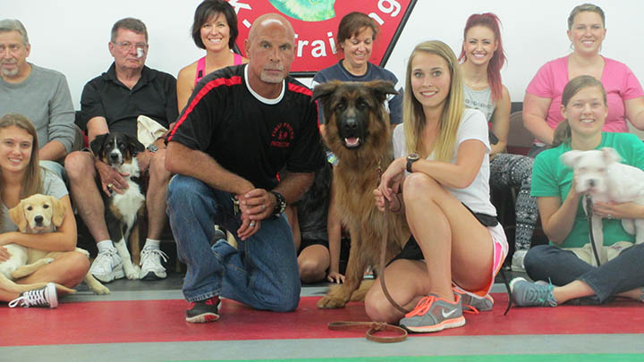 Drill sergeant dog whisperer and Fishers’ business owner Bruce McNabb, with dog Spartacus and Savannah Neary, of Carmel, with some puppy class members. (Submitted photo)