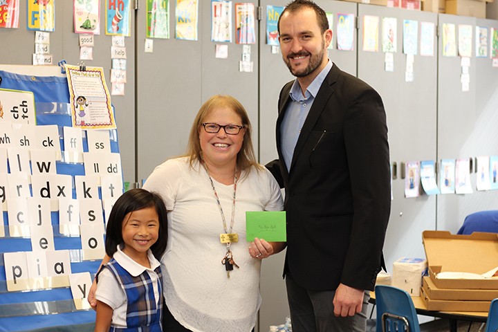 From left, student Lauren Lo with her teacher Elyse Byrd and Market District’s Jason Riley at the class pizza party. (Photo by James Feichtner)