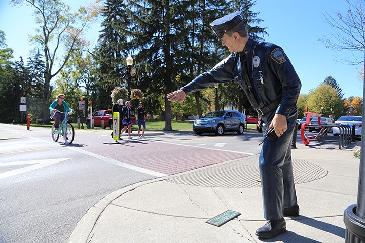 Pedestrians on the Monon Trail cross Main Street near a police officer sculpture. (Photo by Ann Marie Shambaugh)