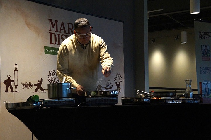 Chef Graham Elliot prepares a dish from his cookbook at Market District. (Photo by Audrey Bailey)