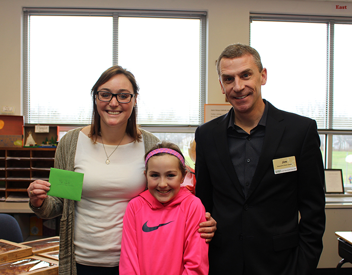 From left, St. Simon fifth-grade teacher Melissa Smith, student Lucy Taylor and Market District’s Jim Griffith. (Photo by James Feichtner)