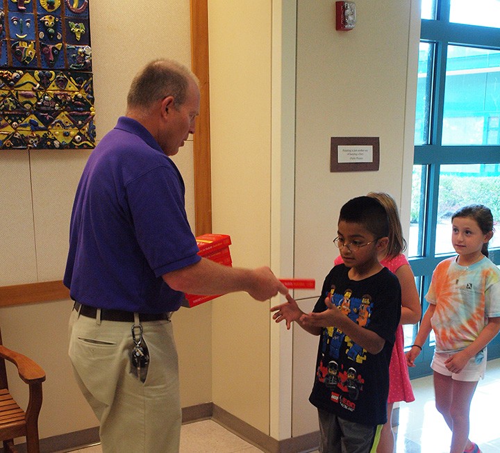 Mark Albright hands out a dictionary to a third grader, one of the many service projects in which the Westfield Lions Club takes part. (Submitted photo)