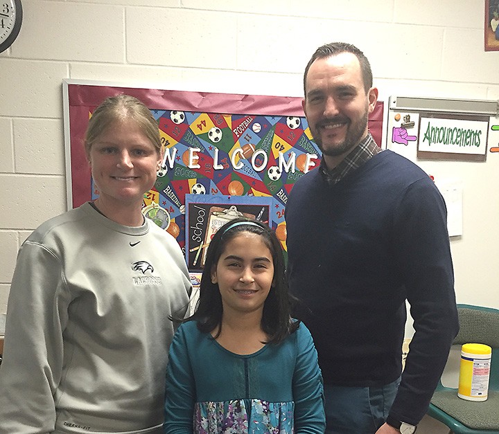 Zionsville Middle School teacher Holly Hook, left, is the January Teacher of the Month. She was nominated by student Mia Wilhite, middle, and she received a gift card from Jason Riley of Market District. (Photo by Anna Skinner)