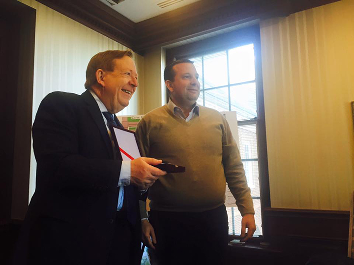 Carmel Mayor Jim Brainard accepts a gift from Preterit Sinajy, mayor of Berat, Albania, during a visit of Albanian mayors to Indiana. Brainard hosted the guests at Carmel City Hall and answered questions about city redevelopment efforts. (Photo by Adam Aasen)