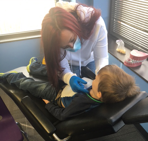 ABA therapist Taylor Wilson works with a child in a setting simulating a dentist’s office. (Submitted photo)