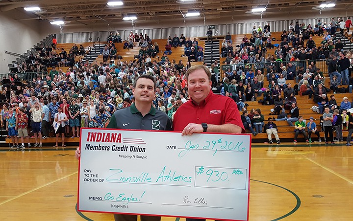 Zionsville Community High School athletic director Greg Schellhase, left, accepts a check from Kevin Jones, manager at the Zionsville branch of Indiana Members Credit Union, at the boys varsity basketball game Jan. 29. (submitted photo)