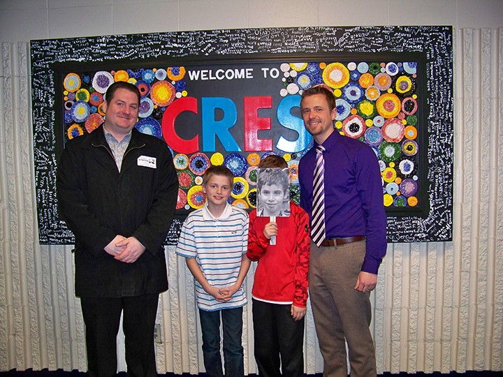 From left, Dan Mixan of Market District, Cumberland Road Elementary School fourth graders Brennan Harvey and, via a stand-in, Casey Alexander, and Teacher of the Month winner John Murch. (Photo by Sam Elliott)