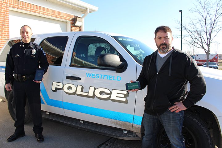 Assistant Chief Scott Jordan, left, and Aaron Sherrick work together to best notify neighborhoods about crime or city information through the mobile app, Nextdoor. (Photo by James Feichtner)