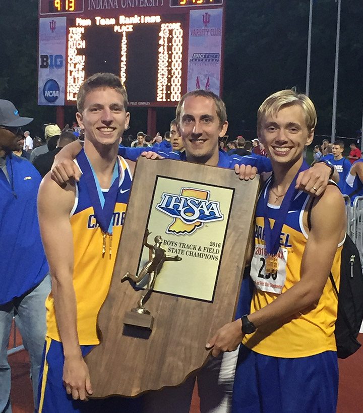 From left, Teddy Browning, coach Colin Altevogt and Ben Veatch celebrate Carmel High School’s second consecutive state title for boys track. (Submitted photo)