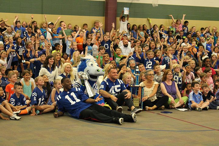 Indianapolis Colts wide receiver Quan Bray (No. 11), mascot Blue (Trey Mock) — with the 2007 Lombardi Trophy — and long snapper Matt Overton (No. 45) pose with Cumberland Road Elementary students and staff during a visit to the school May 25. (Photo by Eric Kuznar)