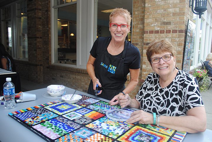 Chris Kus, right, and Nancy Keating pause by the mosaic. (Photo by Anna Skinner)