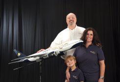 Chris Allen and his wife, Sandy, and son, Samuel, stand with a Legacy Travel Club model. (Submitted photo)