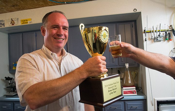 Tom Wallbank gives a toast with his trophy from the Indiana State Fair. Wallbank won the title of Indiana Homebrewer of the Year at the Indiana State Fair.(Photo by Jason Conerly)
